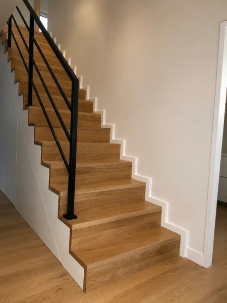 Holztreppe mit schwarzem Stahlgeländer