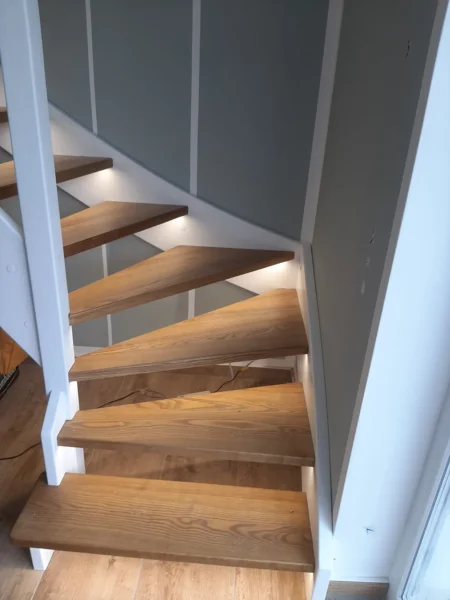 Holztreppe mit weißen Wangen und kontrastierenden Holzstufen