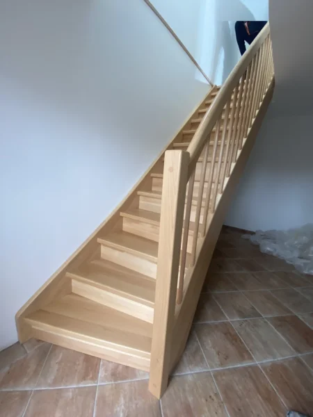Naturfarbene Holztreppe mit Holzhandlauf und Geländerstäben