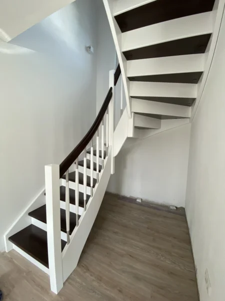 Holztreppe mit weißen Wangen und kontrastierenden Holzstufen