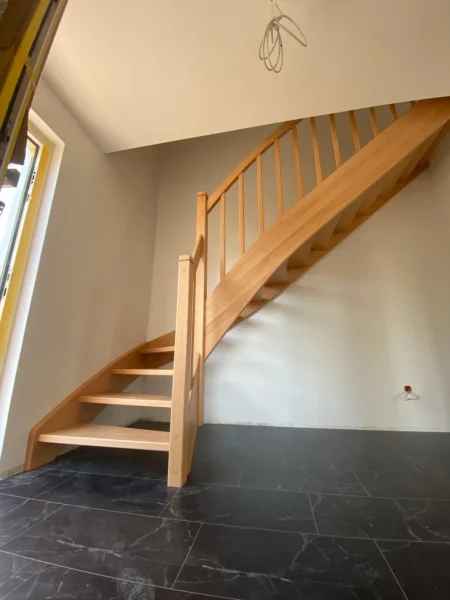 Naturfarbene Holztreppe mit Holzhandlauf und Geländerstäben