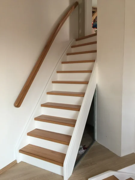 Holztreppe mit weißen Wangen und kontrastierenden Holzstufen