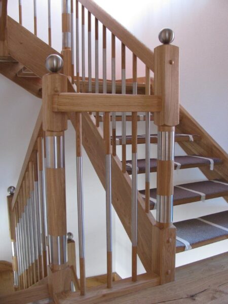 Naturfarbene Holztreppe mit Holzhandlauf und Geländerstäben