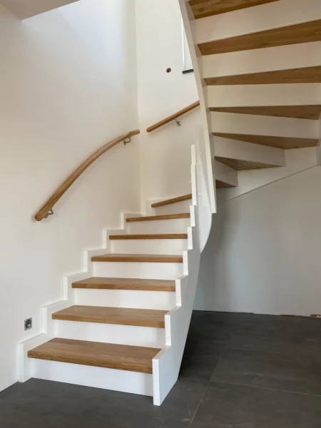 Holztreppe mit weißen Wangen und kontrastierenden Holzstufen