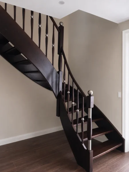 Holztreppe mit dunklen Konstruktionselementen und Handlauf