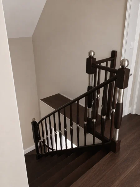 Holztreppe mit dunklen Konstruktionselementen und Handlauf