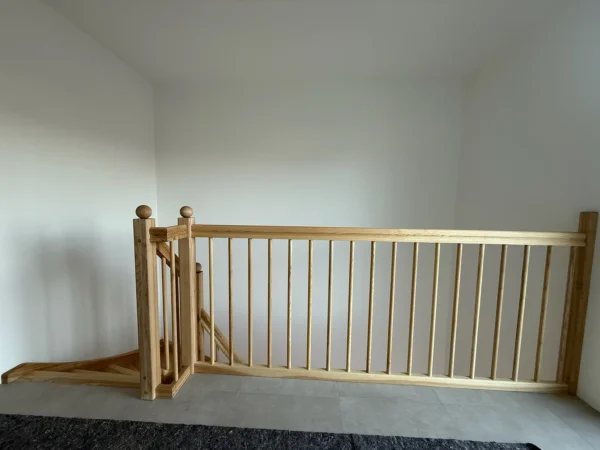 Holzgeländer mit kleinem Tor an einer Treppenöffnung