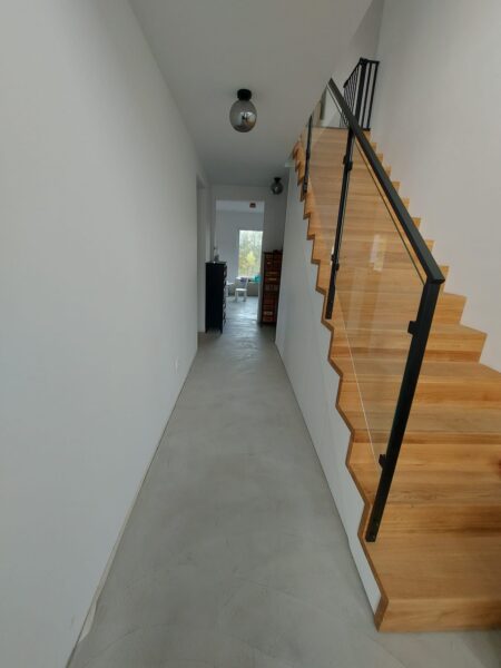 Holztreppe mit schwarzem Stahlgeländer