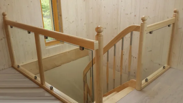 Geländer aus Holz und Glas an einer Treppenöffnung