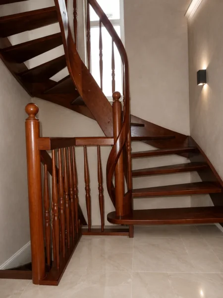 Naturfarbene Holztreppe mit gebogenen Übergängen und Holzgeländer