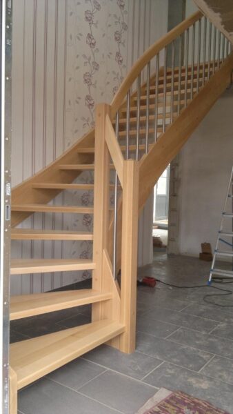 Naturfarbene Holztreppe mit Holzhandlauf und Geländerstäben