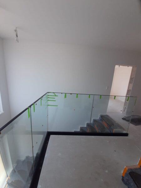 Glasgeländer mit vorläufigen Klebemarkierungen an einer Treppe während der Montage