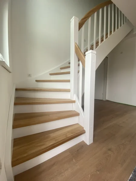 Holztreppe mit weißen Wangen und kontrastierenden Holzstufen