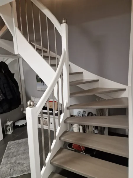 Helle gewendelte Holztreppe mit schlanken Metallstäben