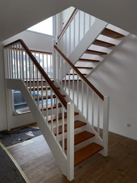 Holztreppe mit weißen Wangen und kontrastierenden Holzstufen
