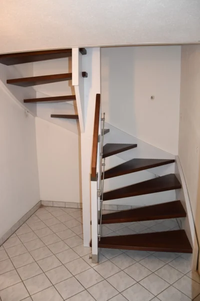 Gewendelte Treppe mit dunklen Holzstufen und heller Konstruktion
