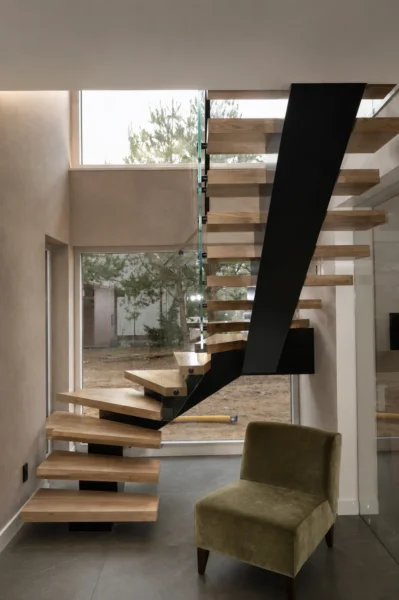 Untersicht einer gewendelten Einholmtreppe vor hohen Fenstern