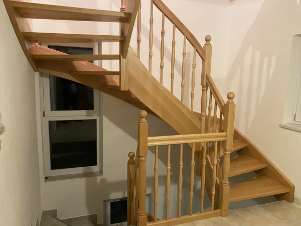 Naturfarbene Holztreppe mit Holzhandlauf und Geländerstäben
