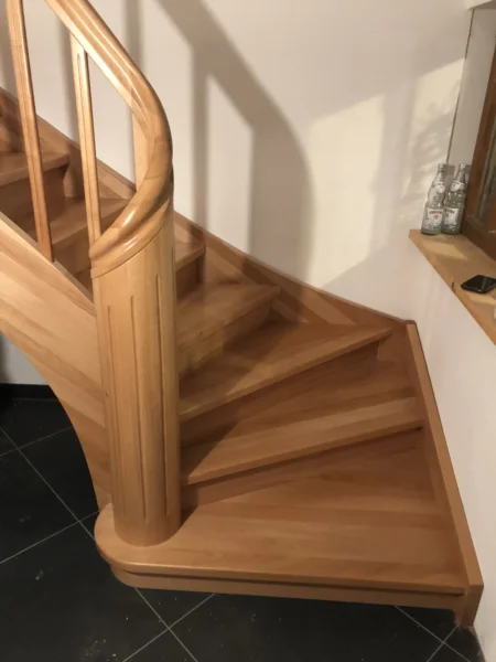 Naturfarbene Holztreppe mit gebogenen Übergängen und Holzgeländer