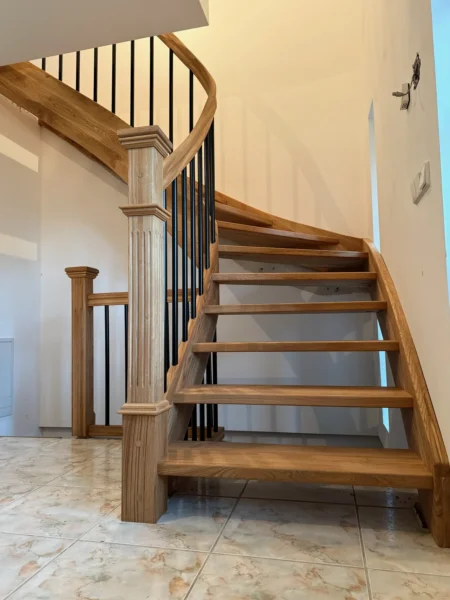 Naturfarbene Holztreppe mit gebogenen Übergängen und Holzgeländer