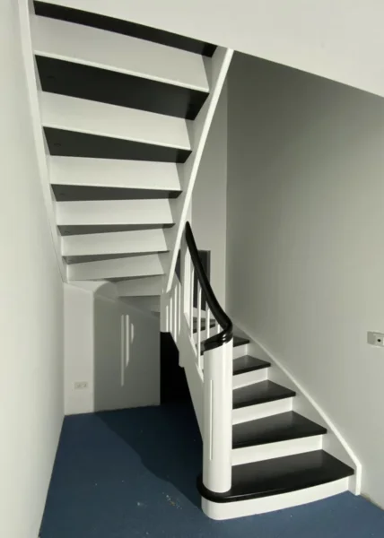 Holztreppe mit weißen Wangen und kontrastierenden Holzstufen