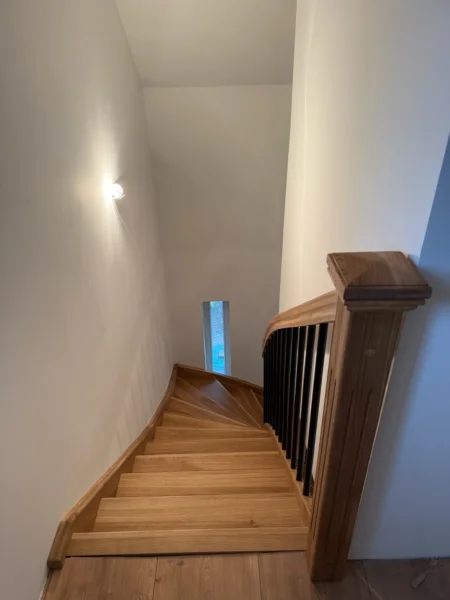 Blick von oben auf Holzstufen mit gedrehtem Treppenverlauf