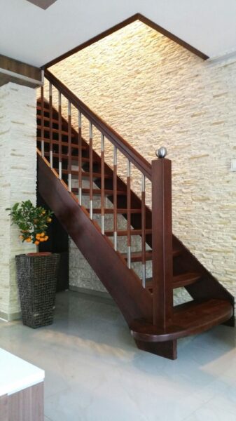 Holztreppe mit dunklen Konstruktionselementen und Handlauf