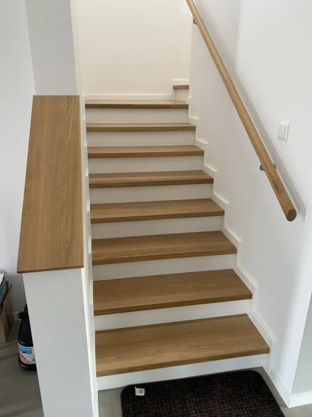 Treppe mit Holzstufen und weißen Setzstufen