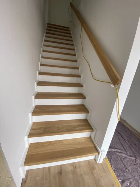 Treppe mit Holzstufen und weißen Setzstufen