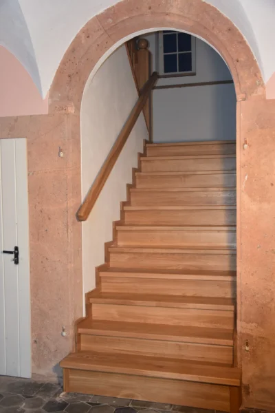 Treppe mit naturfarbenen Holzstufen und Holzhandlauf