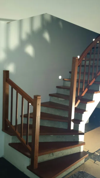 Gewendelte Treppe mit dunklen Stufen und Holzgeländer
