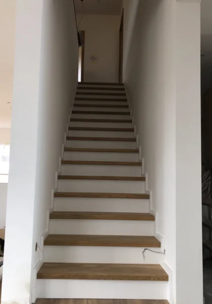 Treppe mit Holzstufen und weißen Setzstufen